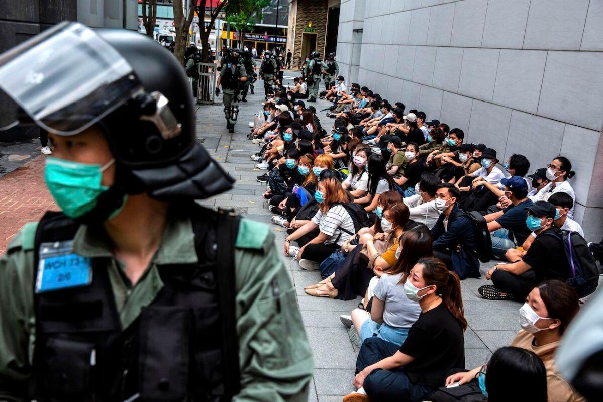 Riot police detain a group of people during a protest in the Causeway Bay district of Hong Kong as the city's legislature debates over a law that bans insulting China's national anthem on May 27, 2020. (Isaac Lawrence/AFP via Getty Images)