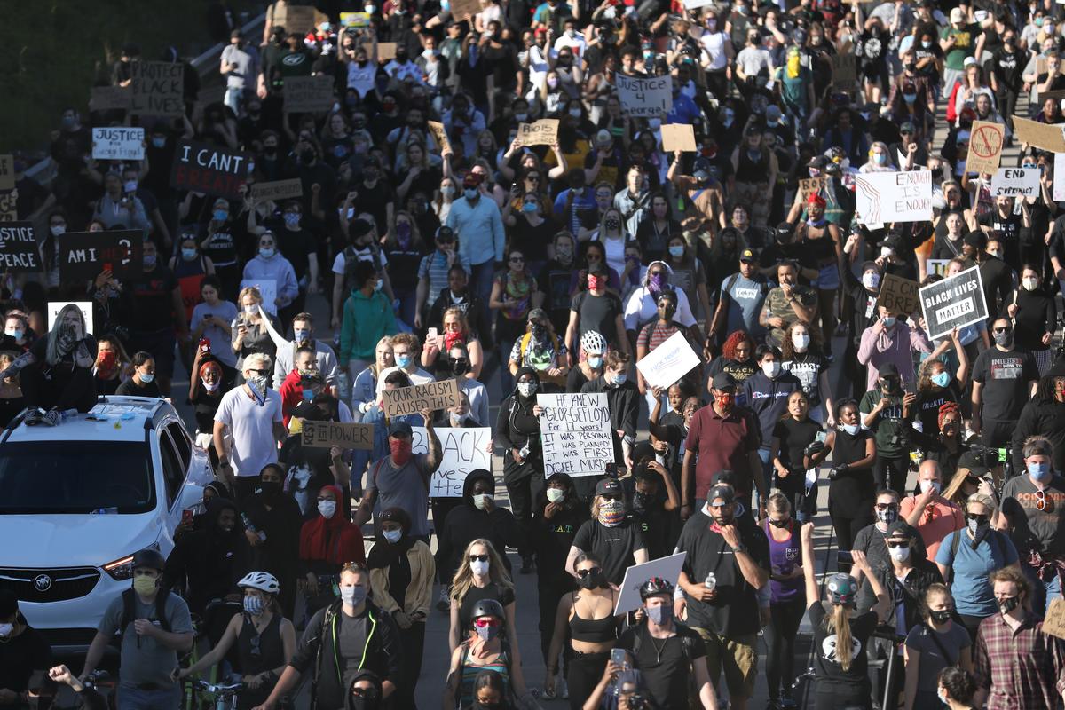 Protesters march along the freeway that exits St. Paul on their way to US Bank Stadium in Minneapolis via the Saint Anthony Falls bridge on the fourth day of protests and violence following the death of George Floyd, in Minneapolis, Minn., on May 29, 2020. (Charlotte Cuthbertson/The Epoch Times)
