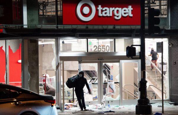 A looter robs a Target store as protesters face off against police in Oakland, Calif., on May 30, 2020, over the death of George Floyd. (Josh Edelson/AFP/Getty Images)