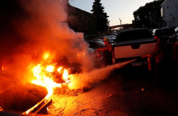 People extinguish fire from vehicles in Minneapolis on May 29, 2020. (Lucas Jackson/Reuters)
