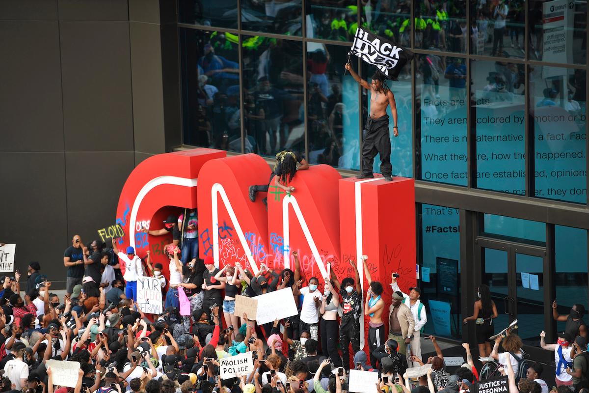 Demonstrators vandalize the CNN logo during a protest march in Atlanta, Ga., on May 29, 2020. (Mike Stewart/AP Photo)