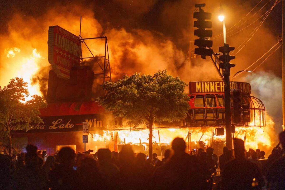 Protesters gather in front of a liquor store in flames near the Third Police Precinct in Minneapolis, Minn., on May 28, 2020. (Kerem Yucel/AFP via Getty Images)