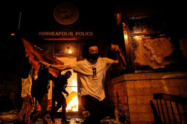 Protesters react as they set fire to the entrance of a police station as demonstrations continue in Minneapolis, Minnesota, on May 28, 2020. (Carlos Barria/Reuters)