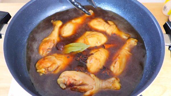 Simmer the drumsticks in the braising liquid with whole spices. (CiCi Li)
