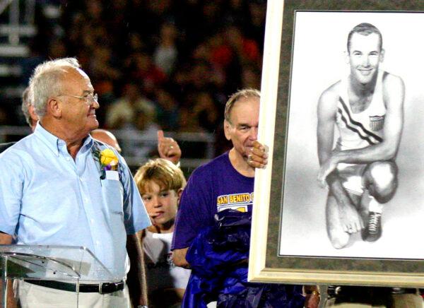 Bobby Joe Morrow, left, is honored with an Olympic portrait of himself during the inauguration of the Bobby Morrow Stadium in San Benito, Texas, at halftime of a football game, on Oct. 13, 2006. (Lynn Hermosa/Valley Morning Star via AP, File)