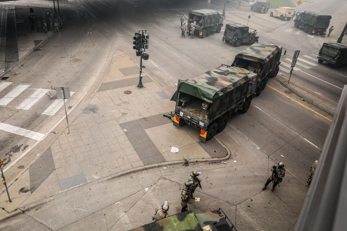 The National Guard sets up near the Lake Street/Midtown metro station as buildings continue to burn in the aftermath of a night of protests and violence following the death of George Floyd, in Minneapolis, Minn., on May 29, 2020. (Charlotte Cuthbertson/The Epoch Times)