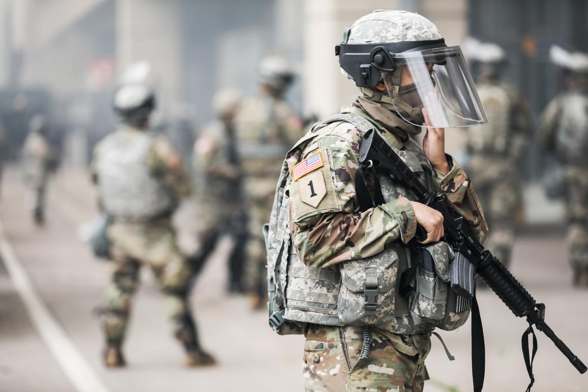 The National Guard sets up near the Lake Street/Midtown metro station as buildings continue to burn in the aftermath of a night of protests and violence following the death of George Floyd, in Minneapolis, on May 29, 2020. (Charlotte Cuthbertson/The Epoch Times)