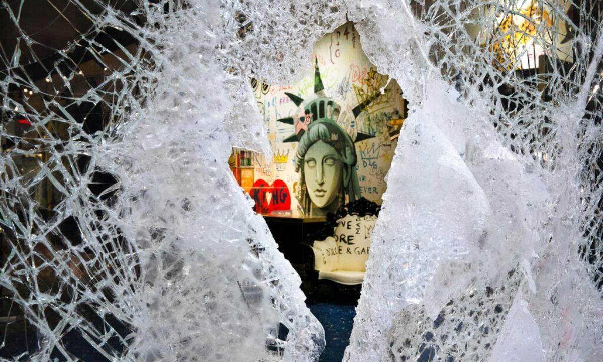 A Statue of Liberty painting is seen through a smashed Dolce and Gabbana store window in SoHo, N.Y., on June 1, 2020. (Mark Lennihan/AP Photo)