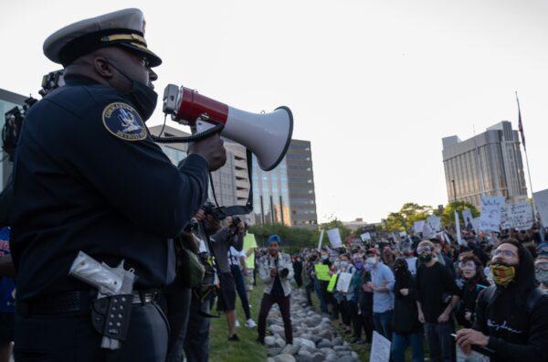 Police officers speak to demonstrators in front of the police station in Detroit, Mich., on May 31, 2020. (Seth Herald/AFP/Getty Images)
