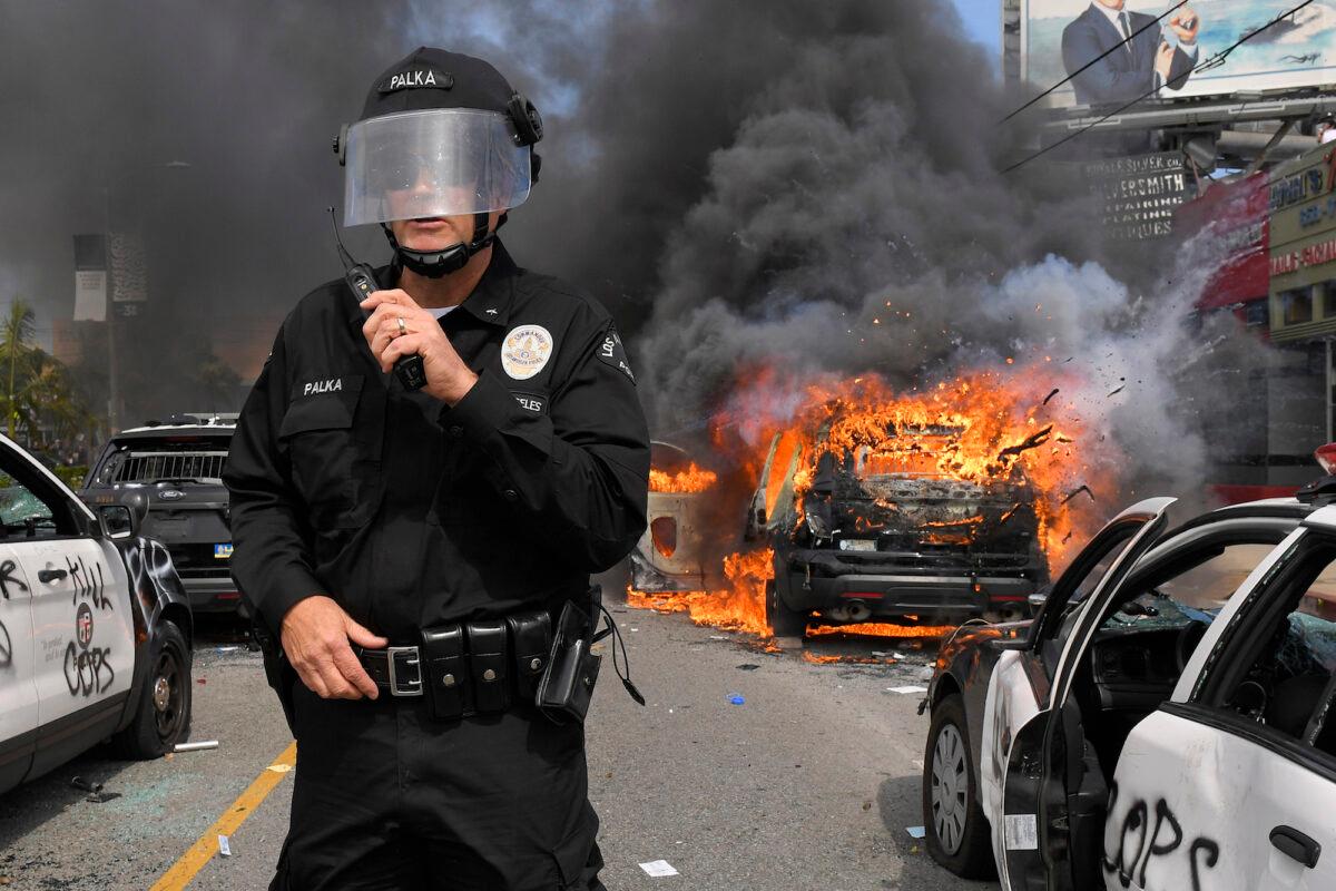 Los Angeles Police Department commander Cory Palka stands among several destroyed police cars in Los Angeles, Calif., on May 30, 2020. (AP Photo/Mark J. Terrill)