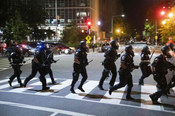 Police run across a street during a demonstration against the death of George Floyd near the White House in Washington on May 31, 2020. (Roberto Schmidt/AFP via Getty Images)