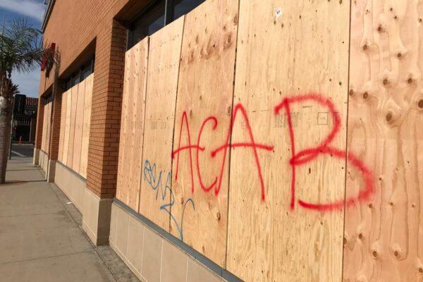 The boards covering the windows of a CVS pharmacy are scrawled with an acronym for an anti-police slogan, in Santa Ana, Calif., on June 1, 2020. (Chris Karr/The Epoch Times)