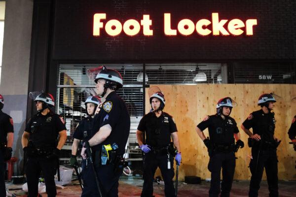 Police stand guard near looted stores during a night of protests and vandalism over the death of George Floyd in New York City on June 1, 2020. (Spencer Platt/Getty Images)