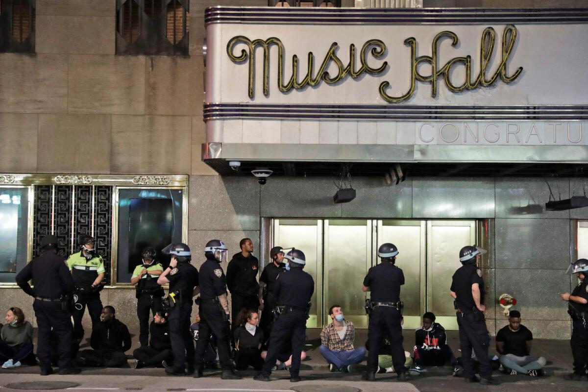 Police officers arrest a large group of people at Radio City Music Hall in New York City, on June 1, 2020. (AP Photo/Seth Wenig)