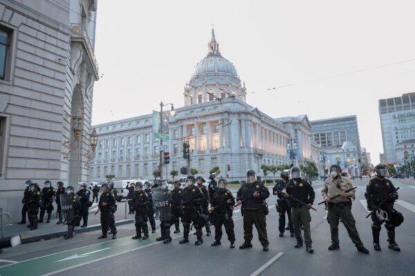 Police officers form a line after moving protesters away from City Hall as the city-wide curfew begins in the wake of the death in Minneapolis police custody of George Floyd, in San Francisco, Calif., on May 31, 2020. (Stephen Lam/Reuters)