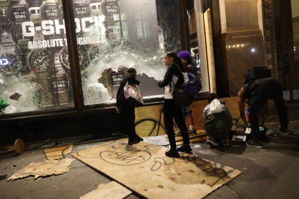 People gather outside a looted store on Broadway during a night of riots and protests in New York City on June 1, 2020. (John Moore/Getty Images)