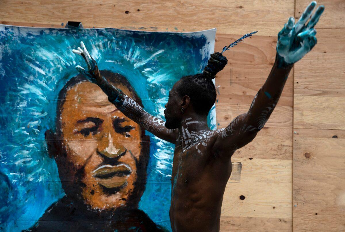 A man paints a portrait of George Floyd in Los Angeles, Calif., on June 2, 2020. (Brent Stirton/Getty Images)