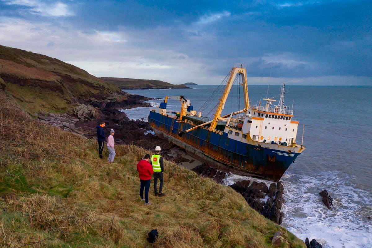 People look down on the abandoned "ghost ship" MV Alta, which drifted without a crew for more than a year before coming aground on Ireland's south coast in high seas caused by Storm Dennis. (CATHAL NOONAN/AFP via Getty Images)