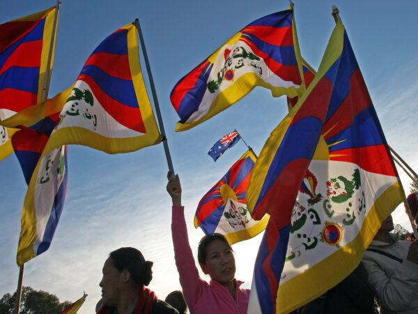 Pro-Tibet protesters display the Tibetan flag outside Parliament House during the Beijing 2008 Olympic torch relay through Canberra on April 24, 2008. (Torsten Blackwood/AFP via Getty Images)