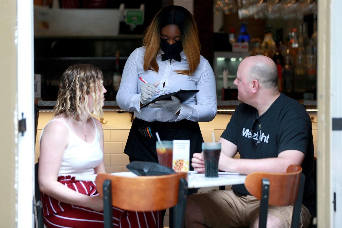 A server takes an order during lunch at Royal House Oyster Bar in New Orleans, La., on May 22, 2020. (Sean Gardner/Getty Images)