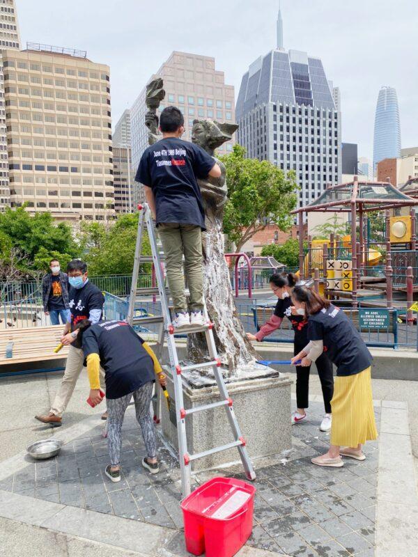Bay Area pro-democracy supporters clean the Goddess of Democracy statue at Portsmouth Square in Chinatown in San Francisco on May 31, 2020. (The Epoch Times)