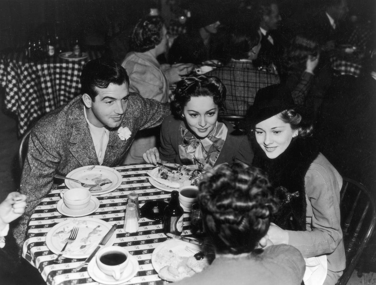 Olivia de Havilland lunching with her sister, Joan Fontaine, and the actor John Payne, circa 1940 (General Photographic Agency/Getty Images)