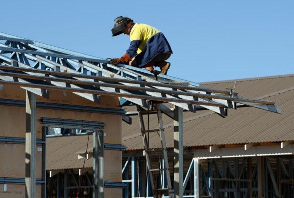 A welder works on the roof of a new house construction at Karratha in the North-West of Western Australia on June 17, 2008. (Greg Wood/AFP via Getty Images)