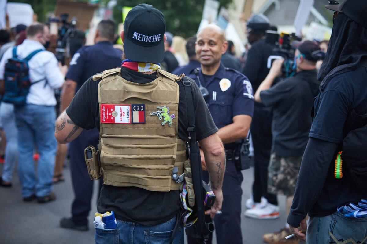 A member of the Boogaloo Bois walks near protesters in Charlotte, N.C., on May 29, 2020. (Logan Cyrus/AFP via Getty Images)
