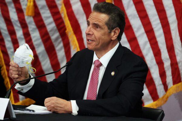 New York Gov. Andrew Cuomo displays the N-95 mask he wears during a CCP virus Briefing At Northwell Feinstein Institute For Medical Research in Manhasset, N.Y., on May 6, 2020. (Al Bello/Getty Images)