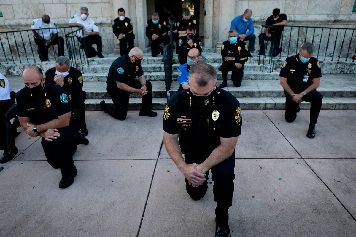 Police officers kneel during a rally in Coral Gables, Florida, on May 30, 2020 (EVA MARIE UZCATEGUI/AFP via Getty Images)