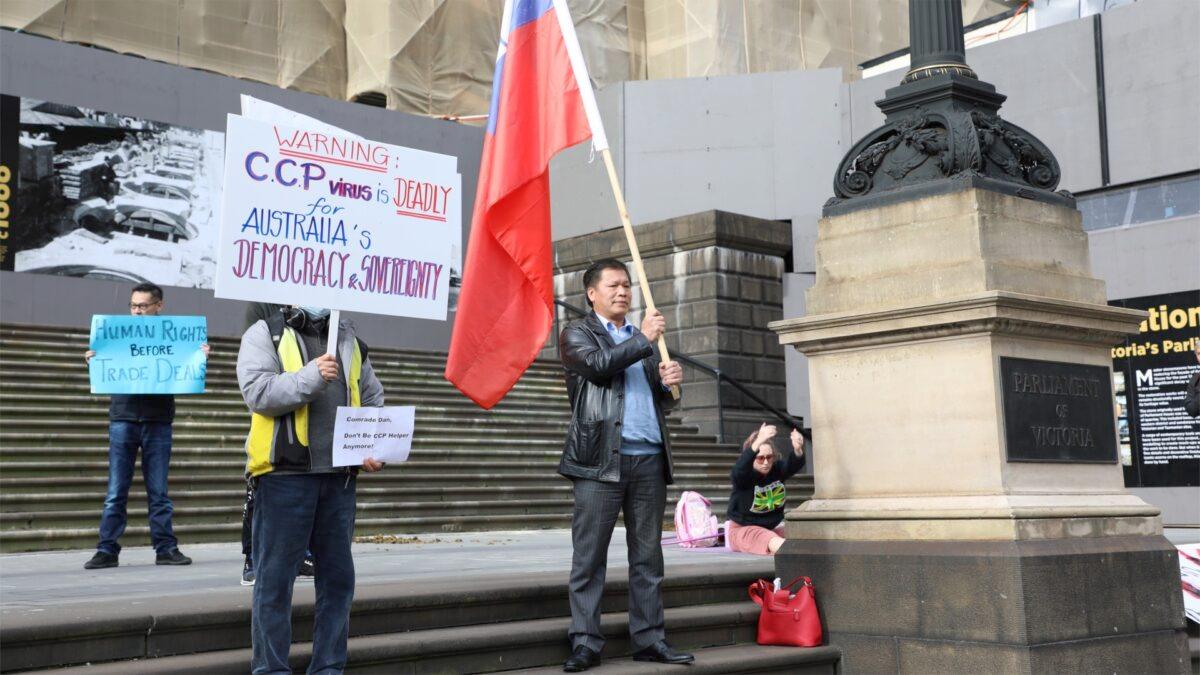 Frank (Ruan) Jie, a member of Overseas Chinese for Democracy movement, holds a Taiwanese flag on the steps of Victorian Parliament House on June 7, 2020. (Grace Yu/Epoch Times)