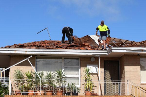 Workers remove roof tiles from a damaged house, Perth, WA, Australia, July 15, 2014. (Paul Kane/Getty Images)