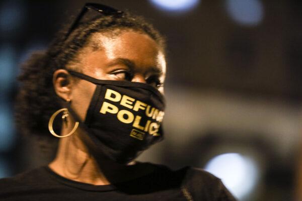 A woman with a “Defund Police” face mask during a protest near the White House following the May 25 death of George Floyd in police custody, in Washington on June 6, 2020. (Charlotte Cuthbertson/The Epoch Times)