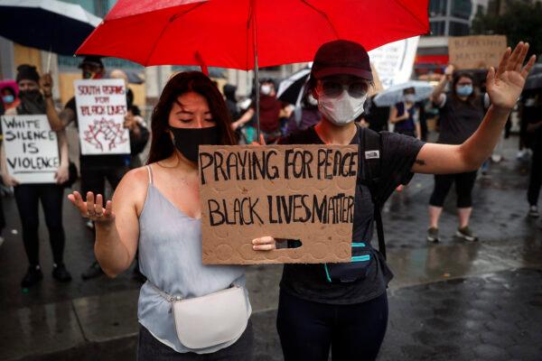 Protesters pray in the rain for a rally at Union Square, in the Manhattan borough of New York, on June 5, 2020. (John Minchillo/AP Photo)