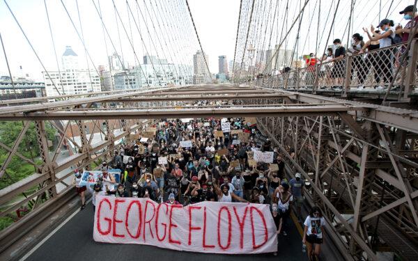People walk over the Brooklyn Bridge following a memorial service for George Floyd, in New York City on June 4, 2020. (Justin Heiman/Getty Images)