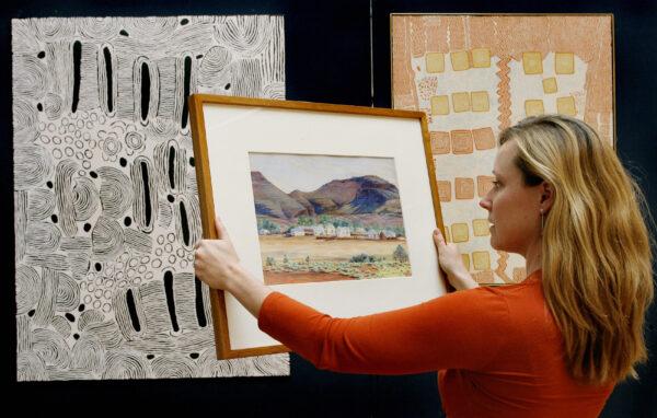 Sotheby's employee holds the first painting by Albert Namatjira painted in 1936, (Wiliam West/AFP via Getty Images)
