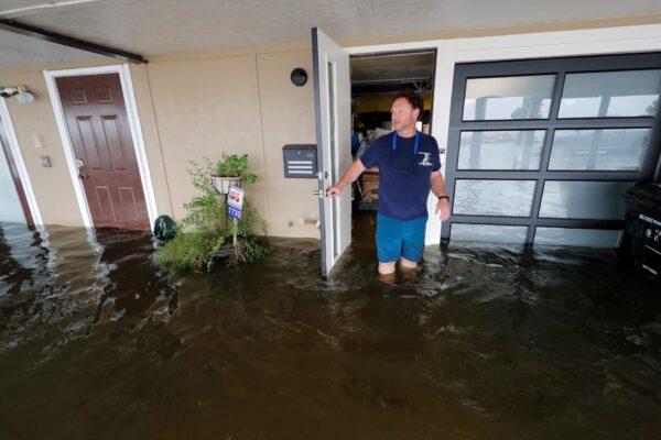 Rudy Horvath walks out of his home, a boathouse in the West End section of New Orleans, as it takes on water a from storm surge in Lake Pontchartrain in advance of Tropical Storm Cristobal, in New Orleans, on June 7, 2020. (Gerald Herbert/AP Photo)