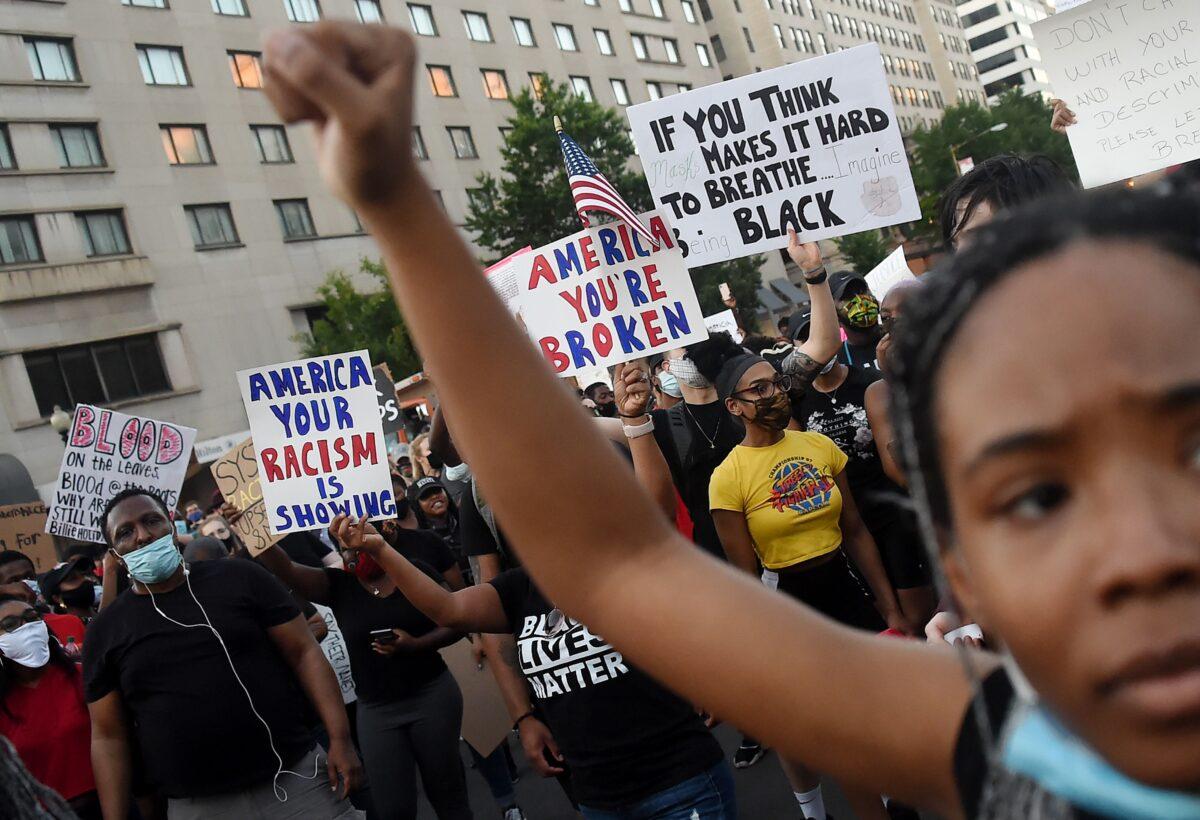 Demonstrators raise their fists as they protest against police brutality and the death of George Floyd, across from the White House in Washington on June 7, 2020. (Olivier Douliery/AFP via Getty Images)