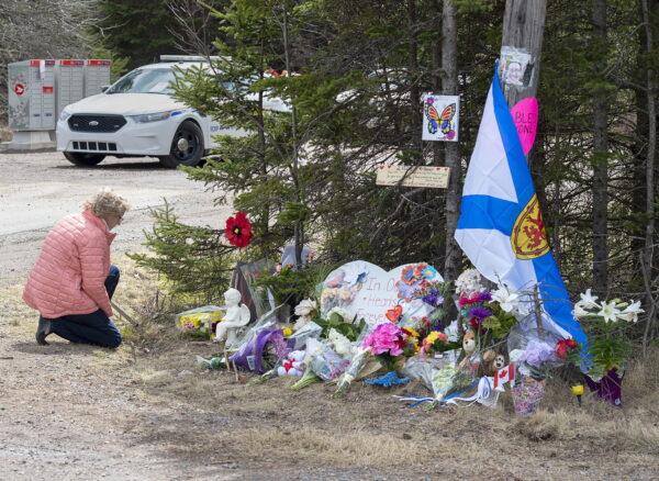 A woman pays her respects to victims of a mass shooting at a roadblock in Portapique, N.S., on April 22, 2020. (Andrew Vaughan/The Canadian Press)