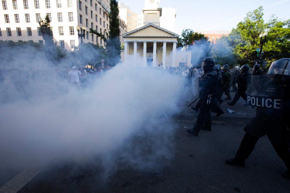 Police officers wearing riot gear push back demonstrators by deploying crowd control devices next to St. John's Church outside of the White House on June 1, 2020. (Jose Luis Magana/AFP via Getty Images)