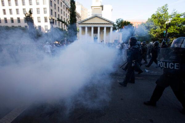 Police officers wearing riot gear push back demonstrators by deploying crowd control devices next to St. John's Church outside of the White House, in Washington, June 1, 2020. (Jose Luis Magana/AFP/Getty Images)