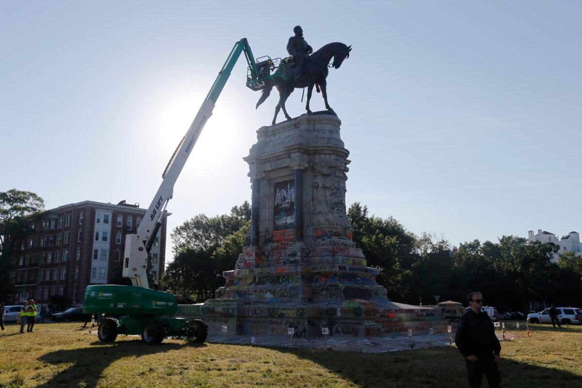 A crew from the Virginia Department of General Services inspects a statue of Confederate Gen. Robert E. Lee on Monument Avenue in Richmond, Va., on June 8, 2020. (Steve Helber/AP Photo)