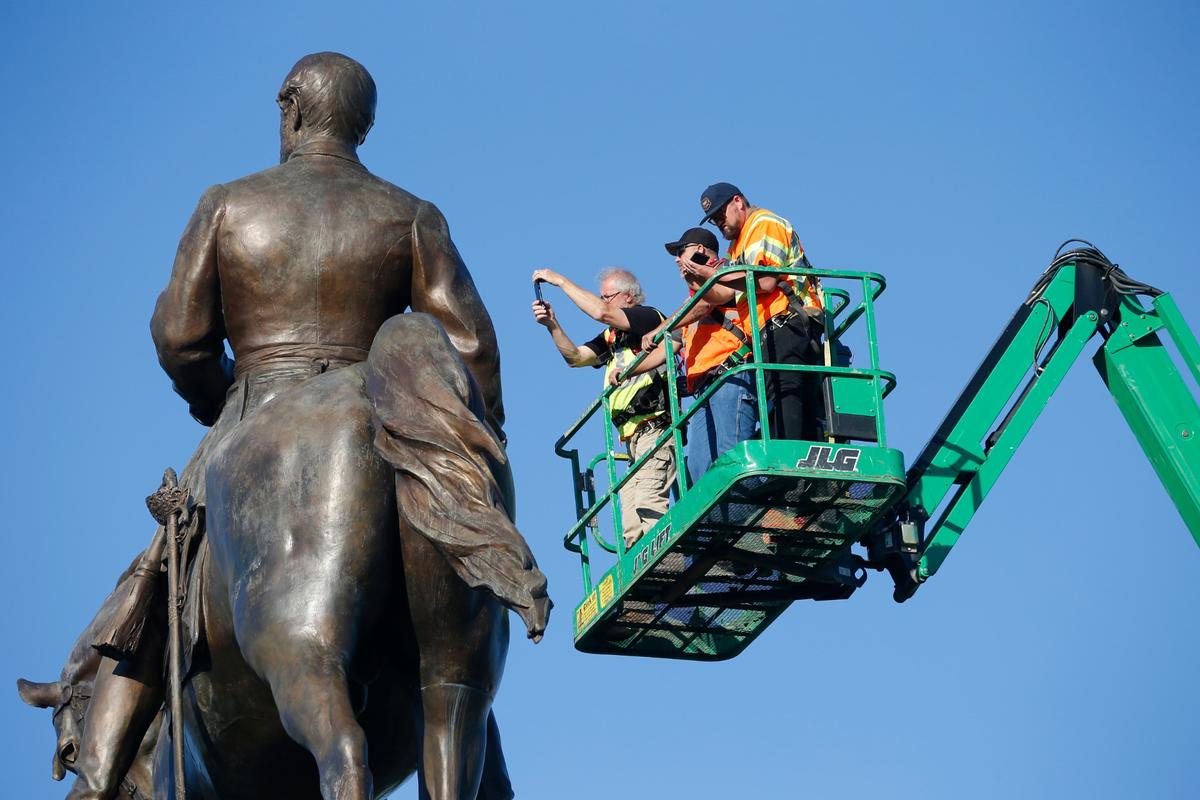 An inspection crew from the Virginia Department of General Services inspect the statue of Confederate Gen. Robert E. Lee on Monument Avenue in Richmond, Va., on June 8, 2020. (Steve Helber/AP Photo)