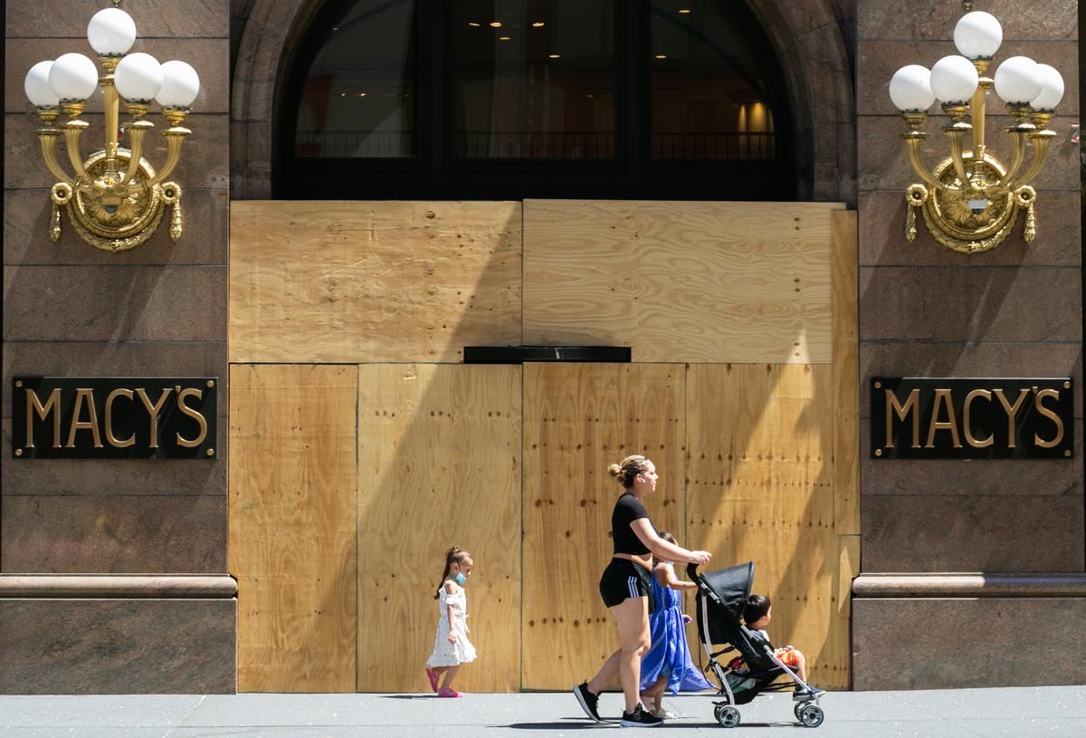 People walk past a boarded up Macy’s store in Manhattan, New York, on June 9, 2020. (Chung I Ho/The Epoch Times)