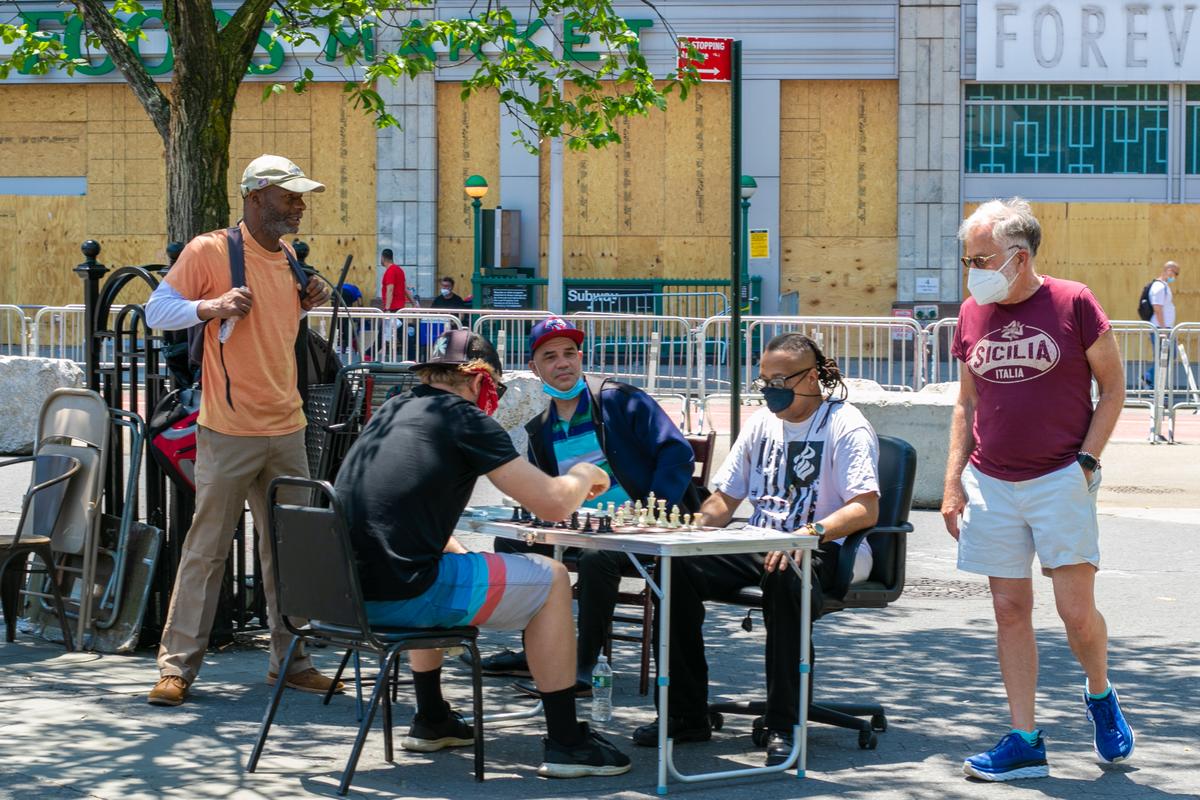 A group of people play chess outside in Manhattan, New York on June 9, 2020. (Chung I Ho/The Epoch Times)