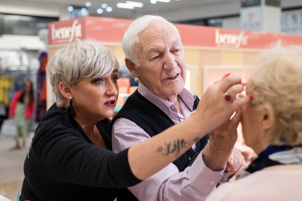 Des Monahan, 84, gets some tips on how to do his wife Mona's makeup from makeup artist Rosie O’driscoll. (Caters News)
