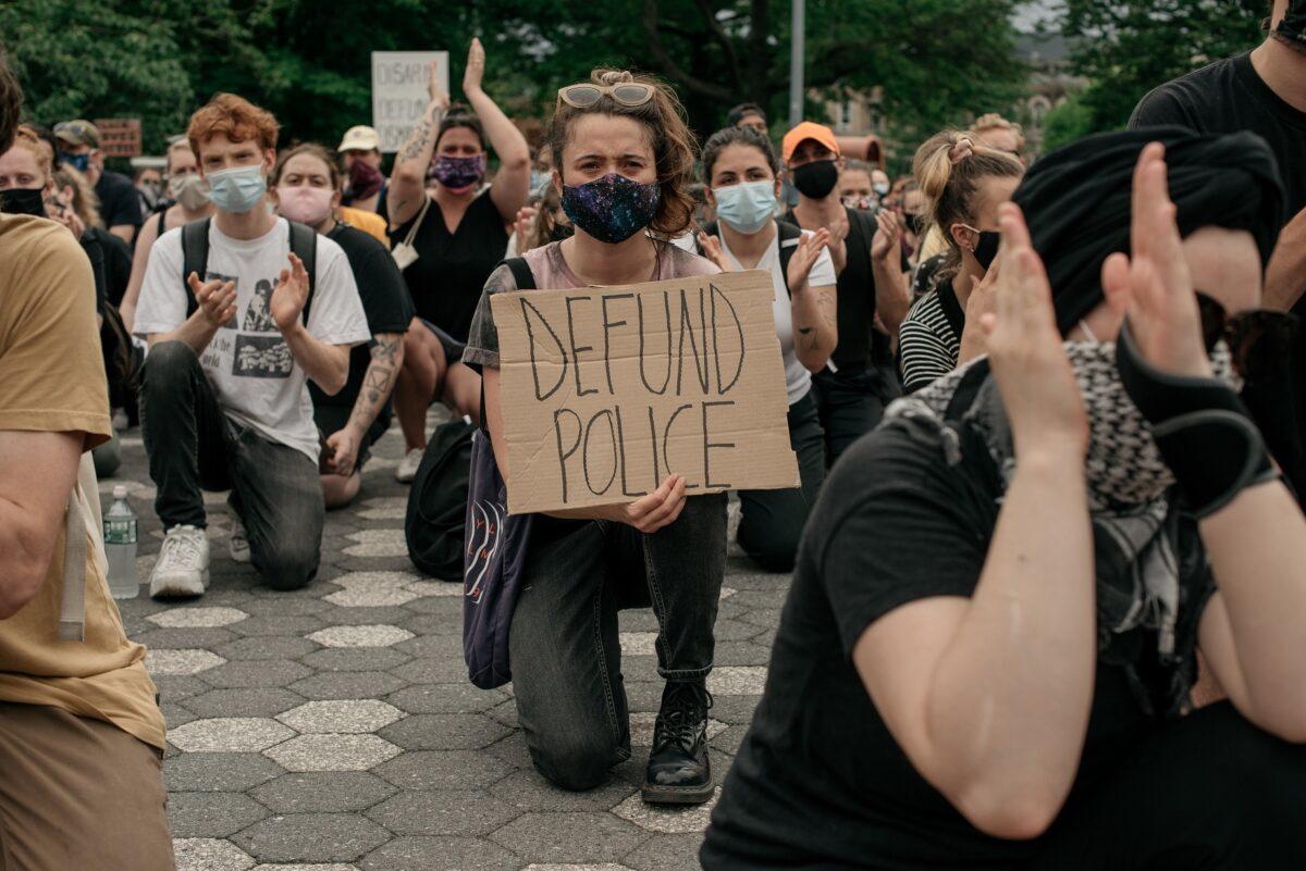 Demonstrators denouncing "systemic racism" in law enforcement and calling for the defunding of police departments kneel in Maria Hernandez Park in the borough of Brooklyn in New York City on June 5, 2020. (Scott Heins/Getty Images)