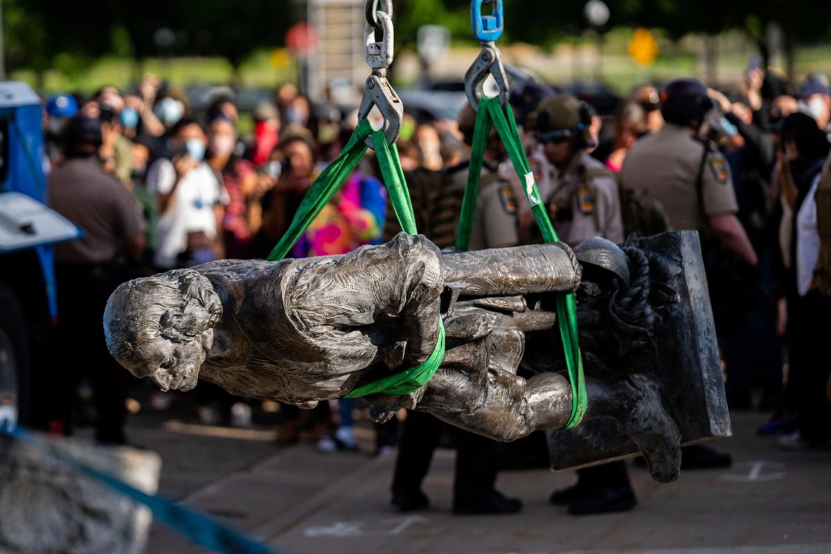 A statue of Christopher Columbus is lifted onto the back of a truck as people sing and celebrate at the Minnesota state Capitol in St. Paul, Minn., on June 10, 2020. (Evan Frost/Minnesota Public Radio via AP)