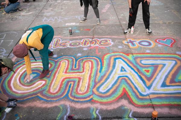 People paint an acronym for "Capitol Hill Autonomous Zone" near the Seattle Police Departments East Precinct in Seattle, Wash., on June 10, 2020. (David Ryder/Getty Images)