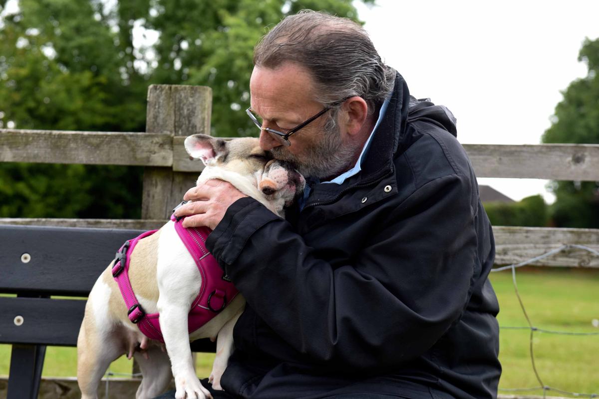 Keith Aspin, 62, plants a kiss on his beloved French bulldog Maja. (Caters News)